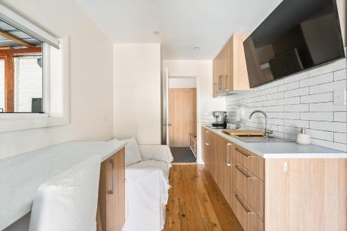 a kitchen with a couch and a sink in it at Romanic Garden View 1 bed Apartment with ocean views at Stanwell Tops in Stanwell Park