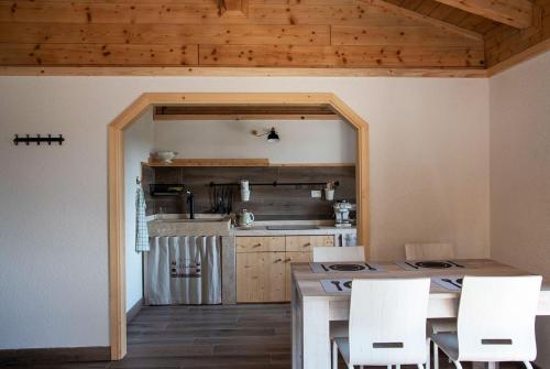 a kitchen with a table and white chairs at Agriturismo Il Pagliaio in Mercato Saraceno