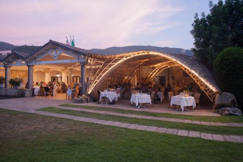 a group of people sitting at tables in a tent at Hotel Golden Gate in Bortigiadas