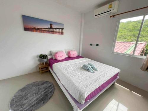 Un dormitorio con una cama con dos animales de peluche encima. en บ้านพักแม่หมูเกาะล้าน, en Koh Larn