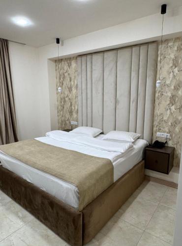 a bedroom with a large bed in a room at Lux Plaza Hotel EVN airport in Arbatʼ
