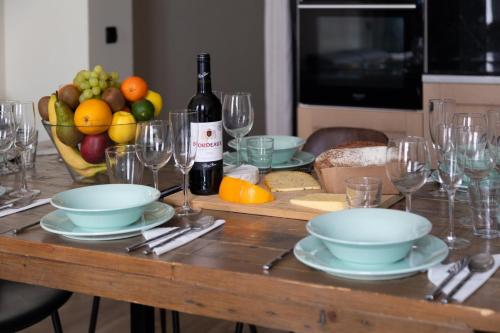 - une table avec des assiettes, des verres et une bouteille de vin dans l'établissement Bluestay 47 - Appartement au cœur de Paris, à Paris
