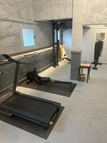 a gym with a person laying on a treadmill at Brit Hotel Privilège Le Royal - Centre Gare in Troyes