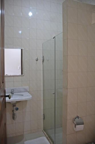 a bathroom with a shower with a sink and a glass door at Pousada Solar Do Triunfo in Triunfo