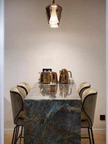 a dining table with chairs and a tea kettle on it at Le XV Cannes in Cannes