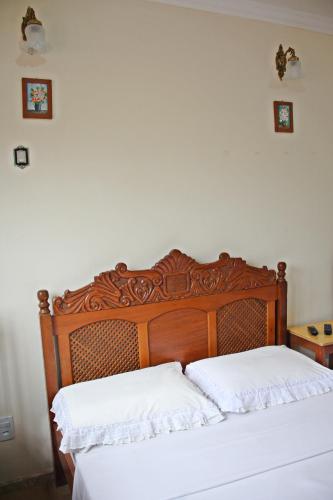 a bedroom with a wooden bed with two white pillows at Pousada Solar Do Triunfo in Triunfo