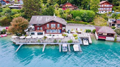 an aerial view of a house on the water at Boutique Hotel Niesenblick - direkt am Thunersee gelegen mit SELF CHECK IN & digitaler Rezeption in Oberhofen am Thunersee