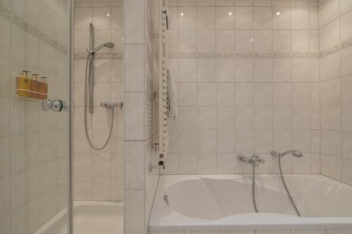 a bathroom with a shower and a bath tub at Strönhof Kampen in Kampen