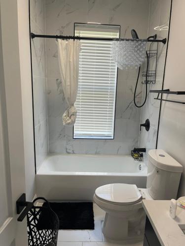 a white bathroom with a tub and a toilet at Mixed Rustic Vibes in Chicago