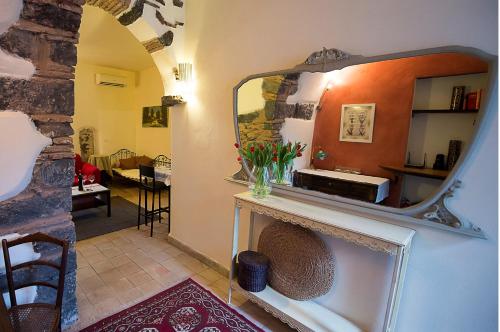 ein Wohnzimmer mit einem Spiegel und einem Kamin in der Unterkunft Etna Dependance in Santa Venerina