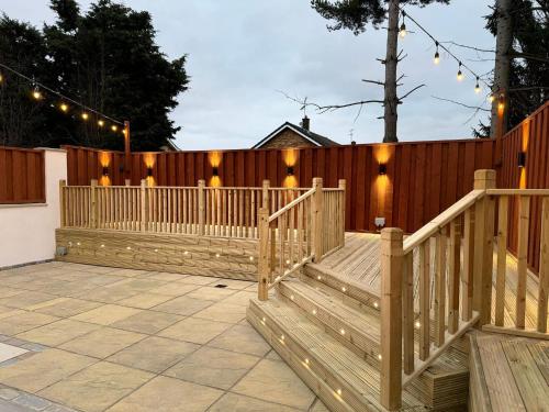 a wooden deck with lights on a fence at Large House for 21 - Nottingham City in Nottingham