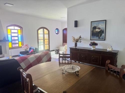 un salon avec un canapé et une table dans l'établissement Casa com lareira em São Bento, à São Bento do Sapucaí
