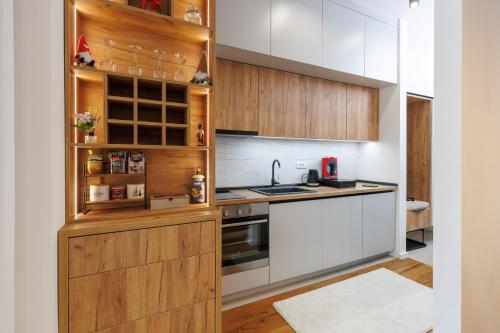 a kitchen with white walls and wooden cabinets at Bjelasnica View Lodge Apartman in Bjelašnica