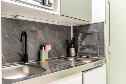 a kitchen with a sink and a counter top at L'Oasis - Studio à 350m de la mer & du centre ville in Saint-Nazaire
