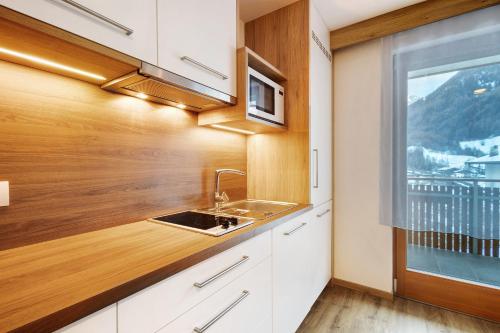 a kitchen with a sink and a window at Pension Waldheim Apartments in San Giacomo