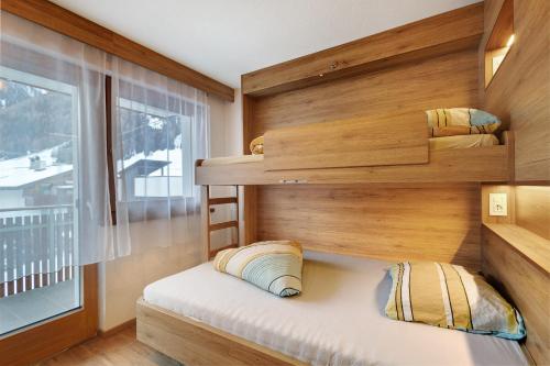 a small bedroom with a bunk bed and a window at Pension Waldheim Apartments in San Giacomo