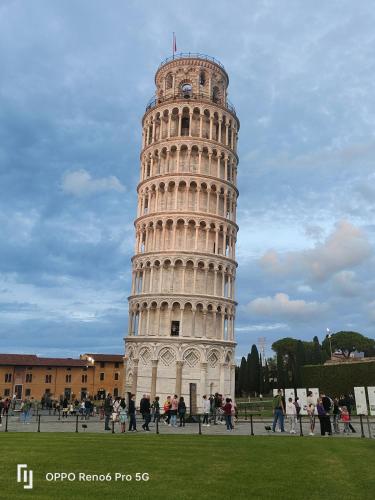 a leaning tower with people standing in front of it at L'ANGOLO di GALILEO in Pisa