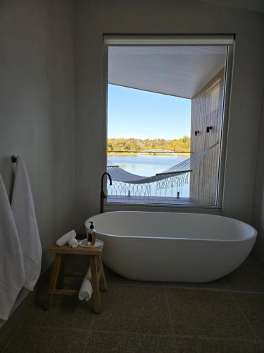 a bath tub in a bathroom with a large window at Edge Luxury Villas in Wilyabrup