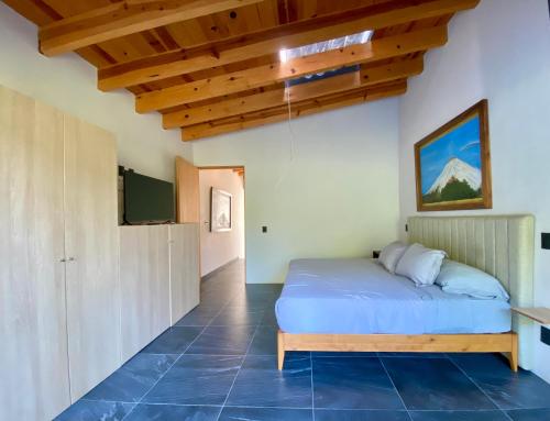 a bedroom with a bed and a tv on a wall at Casa para 6 en Valle, Naturaleza, jacuzzi y descanso in Valle de Bravo