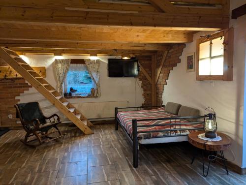 a bedroom with a bed and a tv in a room at Piecówka Wysokie Kaczki in Kaczkowo