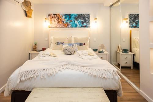ein Schlafzimmer mit einem großen weißen Bett mit zwei Tischen in der Unterkunft Casa Zen in Azenhas do Mar