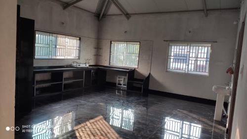 a large room with a kitchen and a sink at Highway Homestay in Kumta