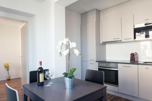 a kitchen with a table with a bottle of wine at HITrental Wiedikon Apartments in Zürich