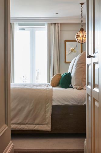 a bedroom with a large bed with a window at Lympstone Manor Hotel Restaurant & Vineyard - Relais & Chateaux in Exmouth