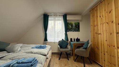ein Schlafzimmer mit zwei Betten und einem Schreibtisch und einem Fenster in der Unterkunft Haus an der Sieber in Herzberg am Harz