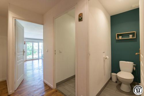 a bathroom with a toilet and green walls at Gîte des moulins in Castelnau-dʼEstrétefonds