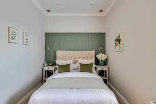 a bedroom with a large bed with two tables at Royal Chester Retreat - Rose Platinum Properties in Chester