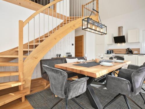 a dining room with a wooden table and chairs and a staircase at Gipfelblick Lodge 5 Pruggern by AA Holiday Homes in Pruggern
