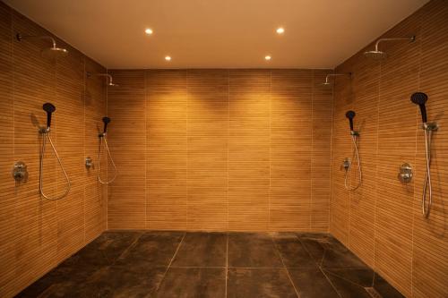 a large bathroom with wooden walls and shower stalls at Amelius Pool Apartments in Caesar Resort SPA, Long Beach in Perivolia tou Trikomou