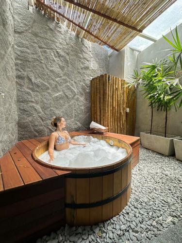 a woman in a bath tub in a room at Passagem Concept Hotel e Spa in Cabo Frio