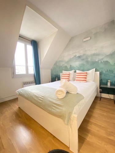 - une chambre avec un grand lit blanc orné d'une peinture murale dans l'établissement Studio Opera Bourse, à Paris