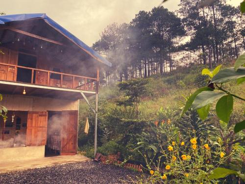 a house on a hill with smoke coming out of it at Mộc Lan’s House in Phi Liêng