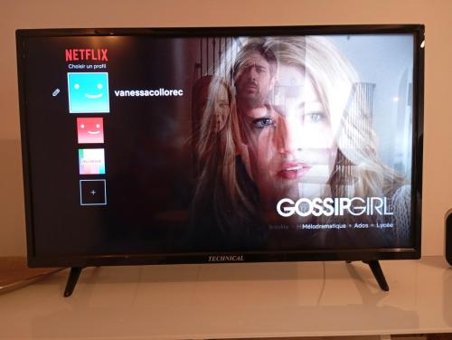 a television with a movie on the screen at Maison atypique et charmante in Pleugueneuc
