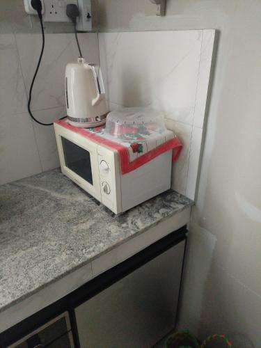 a microwave sitting on top of a counter at Sleepy East Homestay in Lalmatie