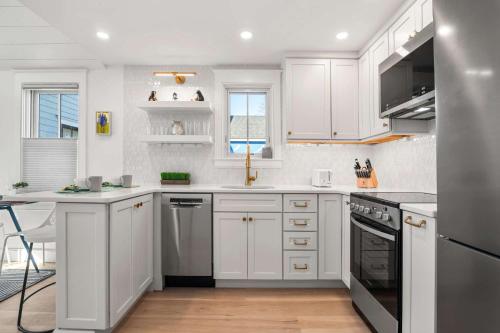 a white kitchen with white cabinets and a sink at Walk to Beach Shopping and Dining in Provincetown