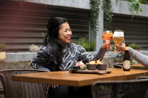 two women sitting at a table with glasses of beer at Hotel Indigo Antwerp City Centre by IHG in Antwerp