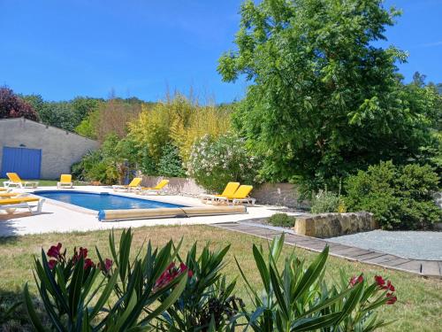 une piscine dans un jardin avec des chaises jaunes dans l'établissement Gîte des Papillons, à Plavilla