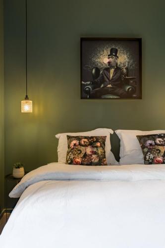 un lit avec une photo d'un homme dans un chapeau dans l'établissement Beige Hospitalité - Jane - Jungle 2 chambres 4 pers wifi Netflix, à Saint-Étienne