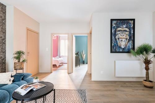 un salon avec un canapé bleu et un tableau mural dans l'établissement Beige Hospitalité - Jane - Jungle 2 chambres 4 pers wifi Netflix, à Saint-Étienne