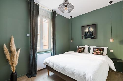une chambre verte avec un lit et une fenêtre dans l'établissement Beige Hospitalité - Jane - Jungle 2 chambres 4 pers wifi Netflix, à Saint-Étienne