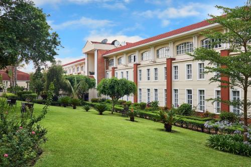 a large building with a lawn in front of it at Protea Hotel by Marriott Blantyre Ryalls in Blantyre