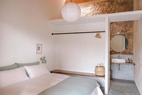 a bedroom with a bed and a mirror and a sink at Casa Comalats in Ametlla