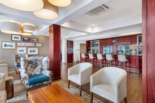 a living room with chairs and a bar at Protea Hotel by Marriott Blantyre Ryalls in Blantyre