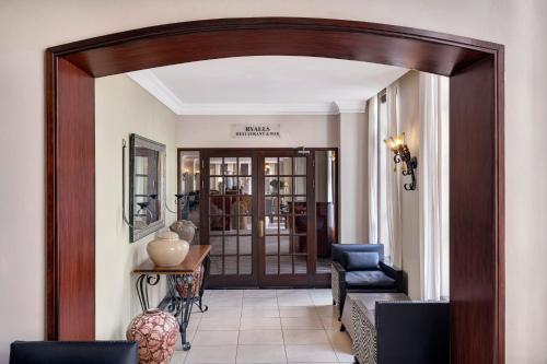 a hallway with a wooden door leading into a room at Protea Hotel by Marriott Blantyre Ryalls in Blantyre