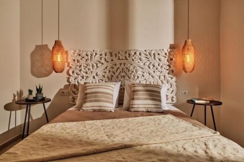 een slaapkamer met een bed met twee tafels en twee lampen bij Villa Danae Periyali in Vasilikos