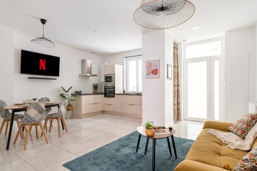 un salon avec un canapé et une table dans l'établissement Beige hospitalité - Capucine - Floral charmant chaleureux wifi Netflix, à Saint-Étienne